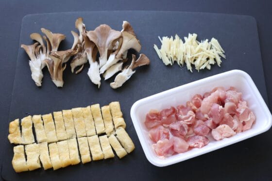 油揚げと舞茸と生姜と鶏もも肉を切る