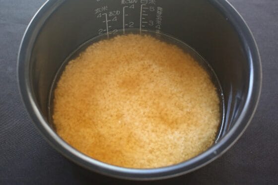 炊飯器の内釜に洗った米を入れて醤油とみりんと酒と出汁と水を加える