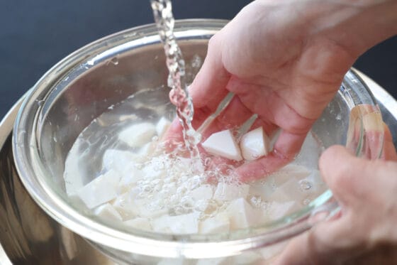 塩でもんだ里芋を水で洗う