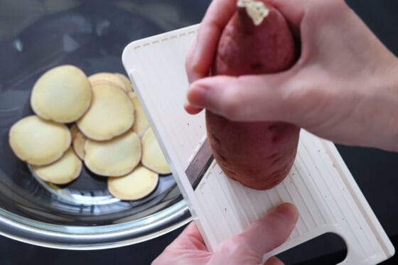 さつまいもを皮付きのままスライサーで薄切りにする