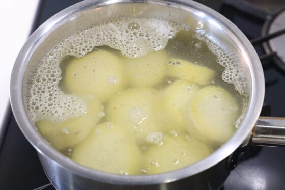 輪切りにしたさつまいもを鍋でやわらかく茹でる