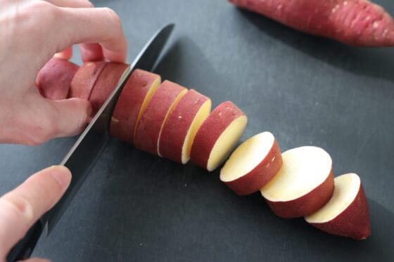 さつまいもを皮つきのまま輪切りにする下ごしらえ