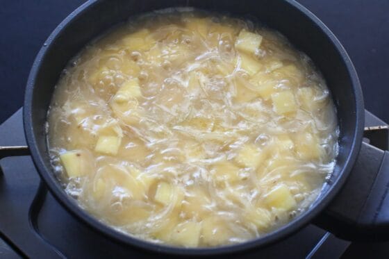 コンソメを加えてさつまいもを煮る