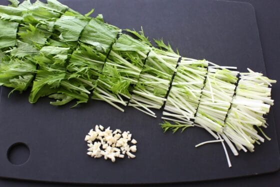 水菜とにんにくを切る