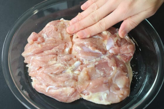 グリルチキン用の鶏肉に塩こしょうとにんにくをすり込む
