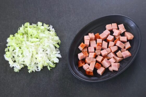 ラードチャーハン用に長ねぎをみじん切りにし焼き豚を角切りにする