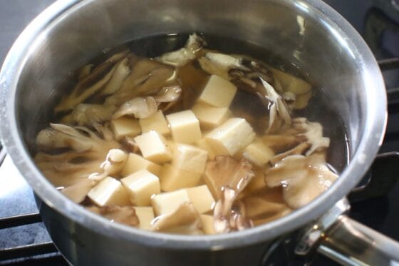 煮た舞茸に絹豆腐を加えて温める