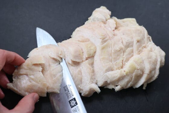 蒸し鶏をそぎ切りにして盛り付ける