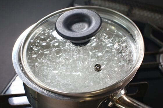 ふたをずらしてかぶせておかゆを弱火で炊く