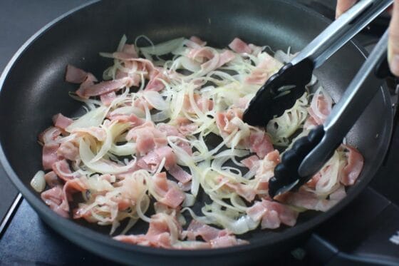 ベーコンと玉ねぎをフライパンで炒めて旨味を引き出す