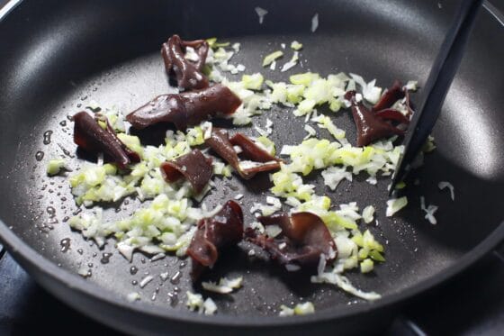 きくらげと長ねぎをフライパンで炒める