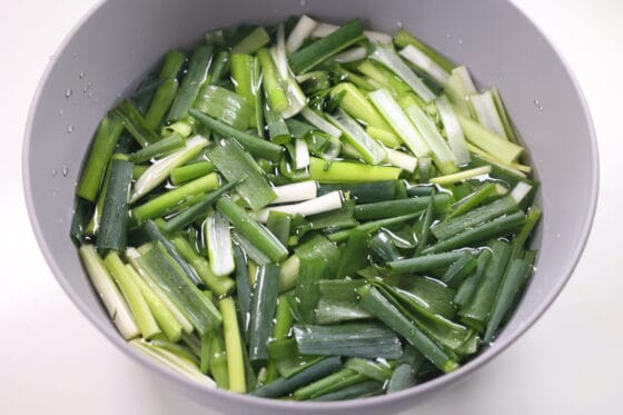 九条ネギを水にさらして辛味を抜く下処理をする