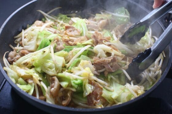 醤油と鶏ガラスープでキャベツもやし豚バラ炒めを仕上げる