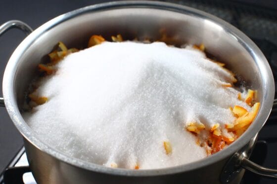 鍋にオレンジと砂糖を入れる