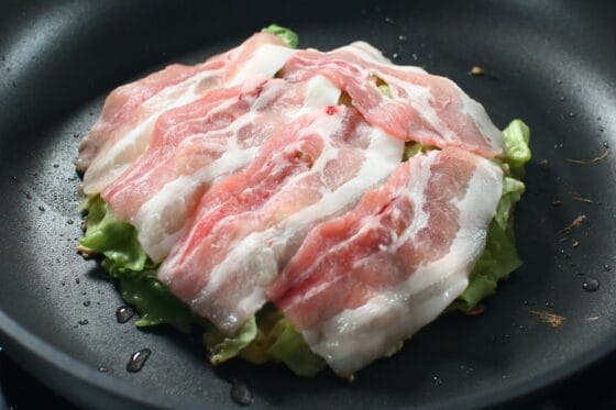 フライパンに生地を広げて豚バラ肉をのせる