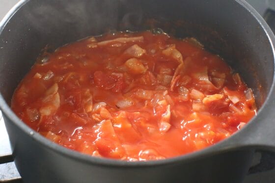 トマト缶を加えてベーコンと玉ねぎと一緒に煮る