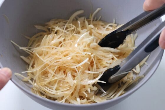 玉ねぎとドレッシングを和えて玉ねぎサラダを作る