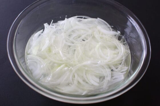 玉ねぎサラダ用にスライスした玉ねぎを水にさらす