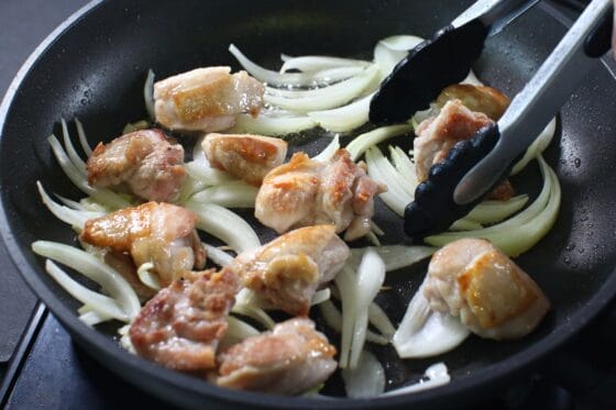鶏肉と玉ねぎをフライパンで炒める