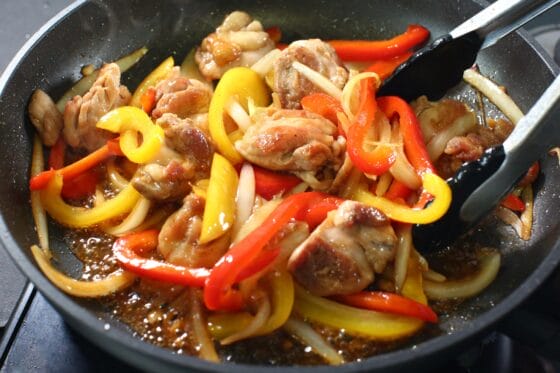 鶏肉とパプリカ炒めに調味料を絡める