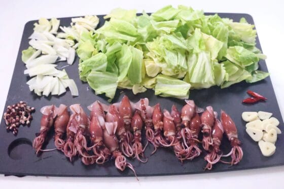ホタルイカの下処理をしてキャベツやにんにくを切る