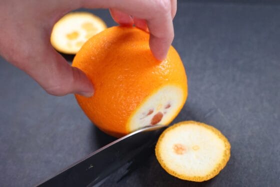 オレンジの上下を切り落として安定させる