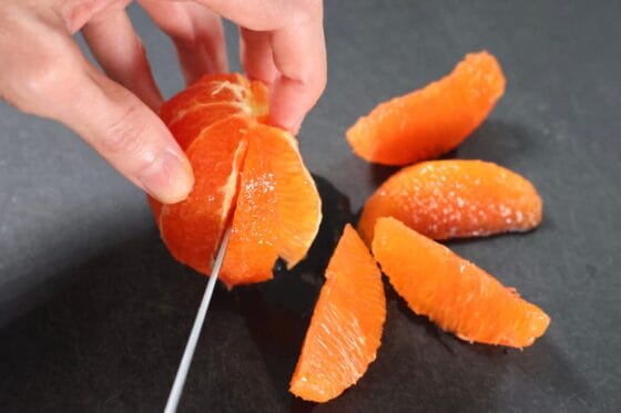 包丁でオレンジの果肉を取り出す