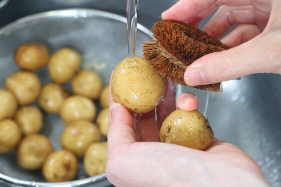 皮付きのままの新じゃがいもを洗う