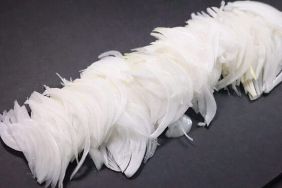 新玉ねぎを繊維に沿って薄切りにする下準備