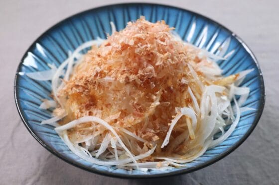 切った新玉ねぎを器にふんわりと盛り付けて醤油とごま油とかつお節をかける