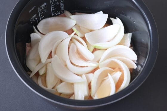 米の上にベーコンと玉ねぎを広げる