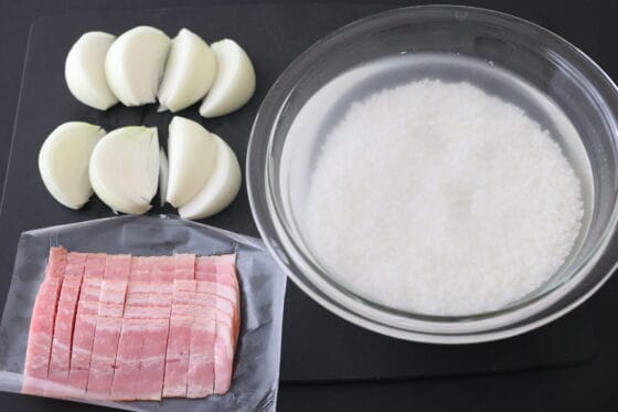 米を洗って浸水させて新玉ねぎとベーコンを切る