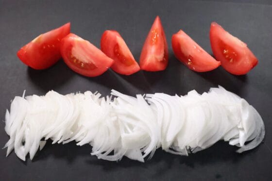 新玉ねぎを薄切りしトマトをくし切りにする下ごしらえ