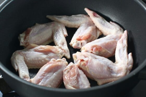 フライパンに水気を取った手羽先を並べて焼き始める