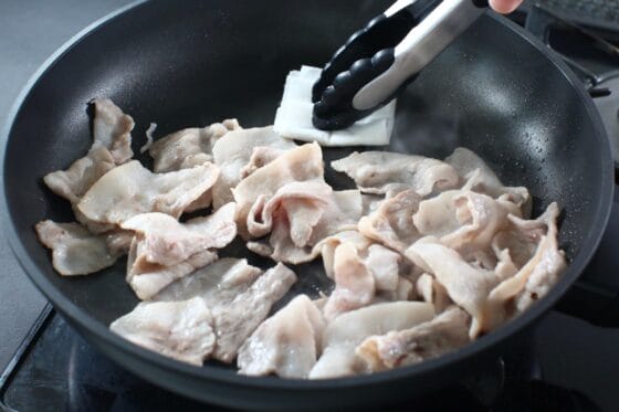 炒めた豚肉から出た脂を拭き取る