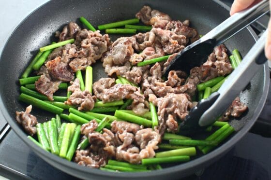 牛肉ににんにくの芽を加えて炒める
