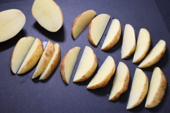 新じゃがを皮付きのままくし形に切る
