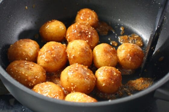 新じゃがの味噌炒めに白いりごまをまぶす