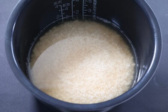 炊飯器に米と調味料を入れて水加減する