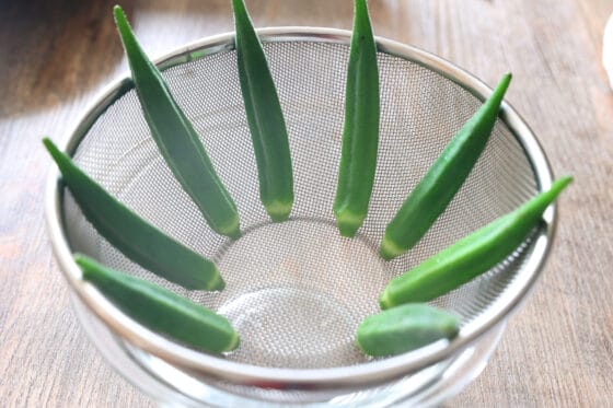 茹でたオクラをザルに上げて水気を切る
