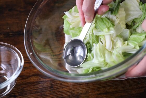 キャベツの入ったボウルに残った蒸し汁の量を調整する