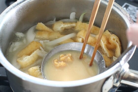 新玉ねぎと油揚げが煮えたら味噌を溶く