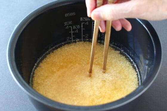炊飯器に米と調味料を入れて水を注いで混ぜる
