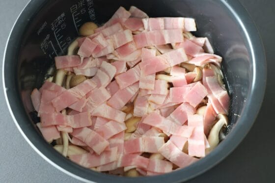 米の上に玉ねぎとしめじとベーコンをのせる