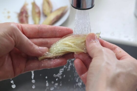 みょうがのぬか漬けの表面についたぬかを、水でさっと洗い流す