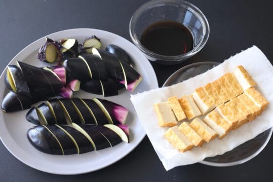 なすと厚揚げを切り、甘辛だれの調味料を混ぜ合わせて下ごしらえをする
