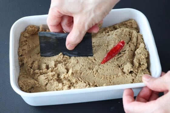 ぬか床に昆布と赤唐辛子を埋める