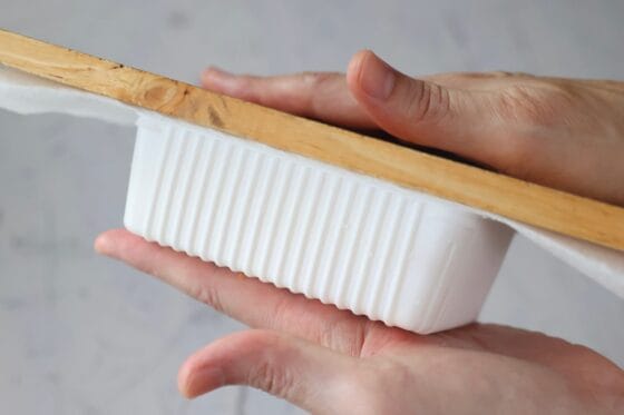 絹ごし豆腐をまな板で押さえ、パックから取り出す