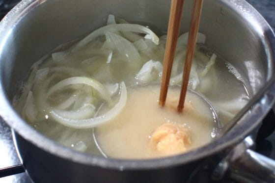 玉ねぎを煮ただし汁に味噌を溶き入れる
