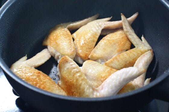 手羽先の両面を中火で焼き、こんがりと焼き色をつける